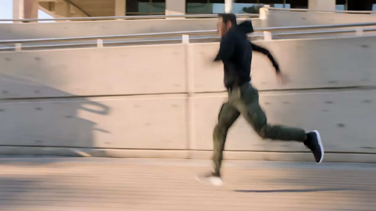 Kling 3 Pro AI video example: A confident American man in his early 30s, athletic build, wearing a dark hoodie, cargo pants, and sneakers...