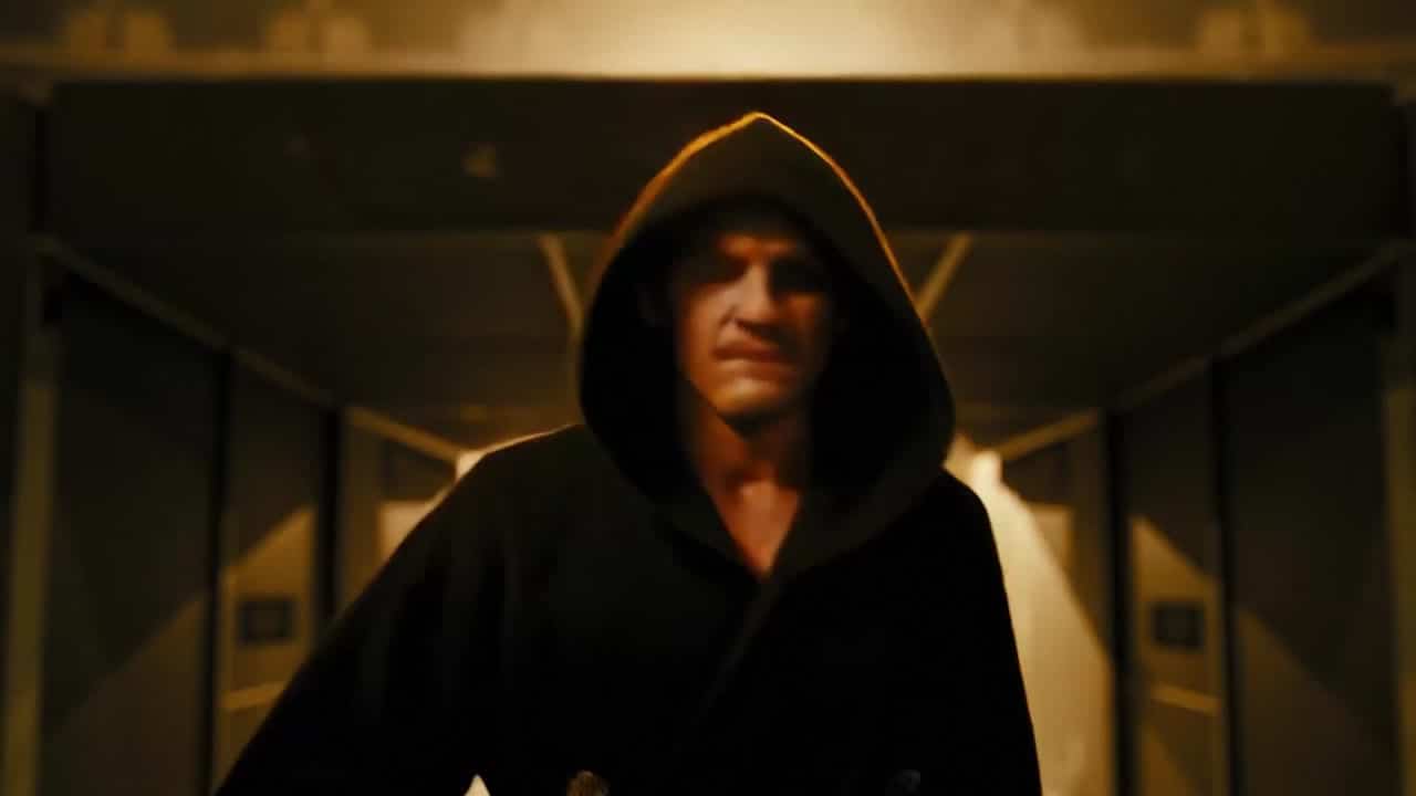 LTX 2.3 Fast AI video example: A powerful boxer walks alone through a dark arena tunnel toward the ring, athletic frame wrapped in a hood...